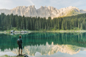 Man standing and looking at Lago di Carezza in Dolomites