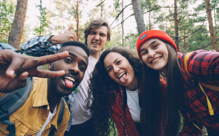 Group of four mix ethnicity individuals pose for a selfie