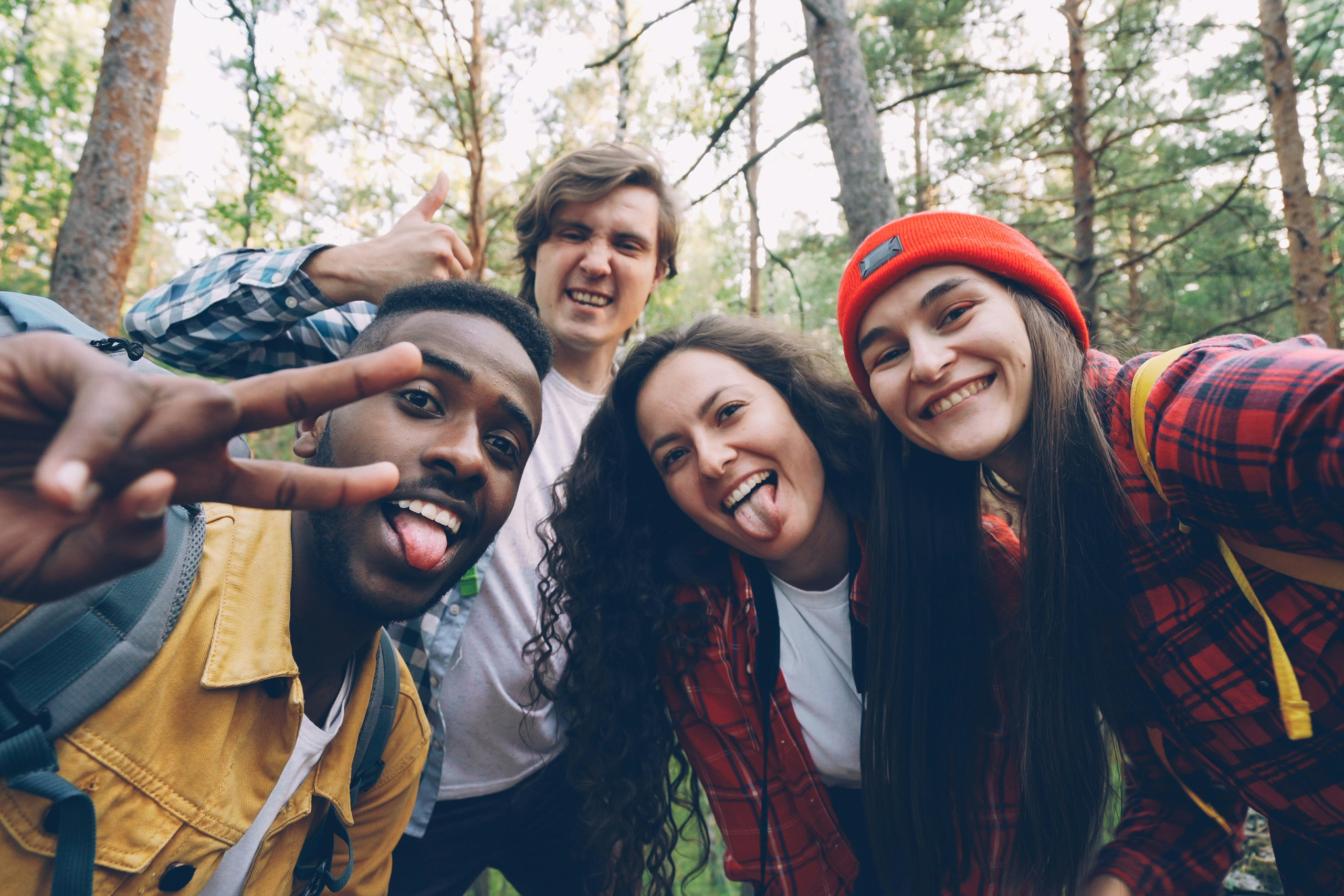 Group of four mix ethnicity individuals pose for a selfie